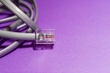 internet ethernet cable connection cord purple background. macro closeup shot. copy space.