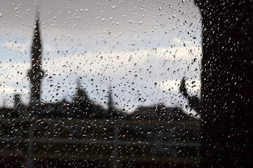 Raindrops on the glass. Minaret as silhouette