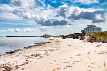 house on stilts with a broken pier on the Atlantic Ocean in North Carolina.