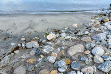 A peaceful shoreline dotted with smooth stones caressed by the soft lull of evening waves.