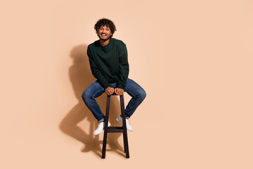 Full length photo of attractive positive guy dressed sweatshirt sitting bar chair emtpy space...