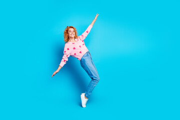 Full length photo of lovely young lady tiptoes have fun dressed stylish pink clothes isolated on blue color background
