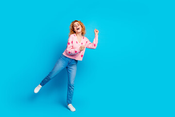 Full length photo of attractive young woman dancing have fun dressed stylish pink clothes isolated on blue color background