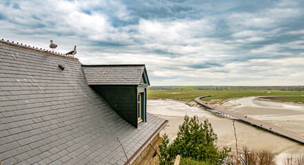 Mont-Saint-Michel, Normandy, France: View of the bridge from Mont-Saint-Michel with two doves on a...
