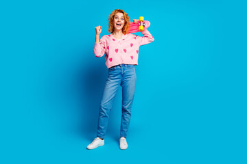 Full length photo of attractive young woman hold skateboard winning dressed stylish pink clothes isolated on blue color background