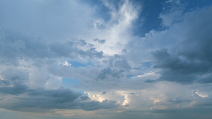 Summer skyscape with dark storm rain clouds on sky. Clouds against a blue sky turning into dark rain cyclones. Timelapse.