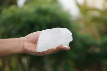 Close up hand holds crystal clear white alum stones or Potassium alum Useful for beauty and spa...
