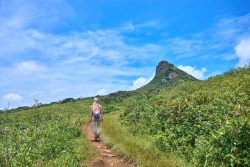 Naklejka premium Woman is hiking in mountains. Travel adventure during vacation, outdoor healthy lifestyle and eco tourism