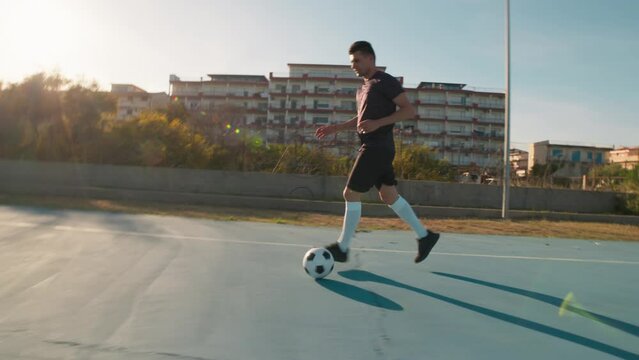 Man Running With The Ball On An Urban Pitch 