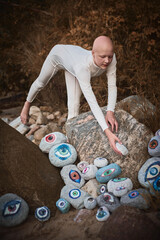 Young hairless girl with alopecia in white futuristic costume reaches hand for surreal landscape...