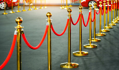 Gold support posts with red velvet textile fabric rope fencing, access control, vip only at an...