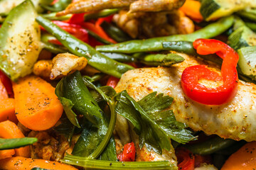 Stir fry chicken wings with vegetables in a wok. Spicy asian food concept.