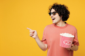 Young smiling amazed happy man he wear pink t-shirt casual clothes 3d glasses watch movie film hold...