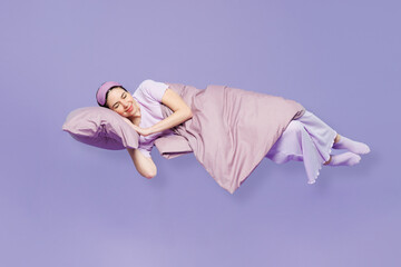 Full body side view young calm woman wear pyjamas jam sleep eye mask rest relax at home fly up...