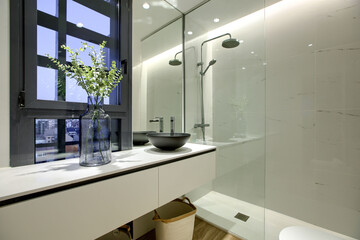 Blue decorative vase in a modern style bathroom with a shower cabin with a tempered glass screen...