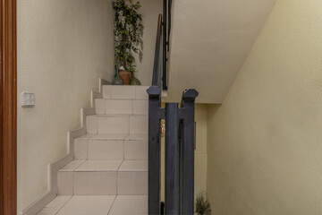 Interior stairs of a multi-story residential house with black metal railing and light gray...