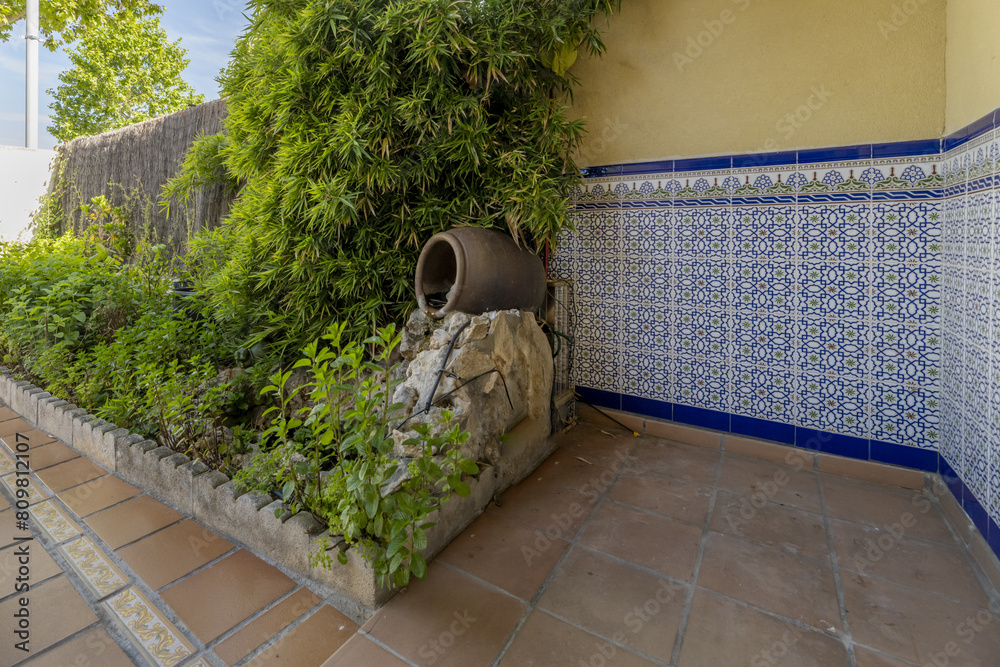 Wall mural entrance of a chalet with terracotta floors with spanish style tiles on half of the wall and a potti