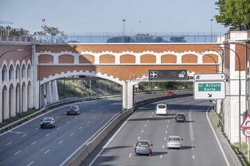 An urban entrance road to Madrid with a traffic information monitor and indicative signs