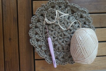 raffia balls . A bobbin of yarn lies on hooks. side view of a textile reel. Straw yarn and hook