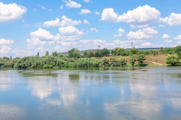 Landscape with river and blue sky with white clouds on summer day