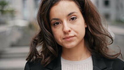 Caucasian girl standing around grey modern building in the center of the city. close-up, slow motion. Woman looking into a camera, smiling, looking around