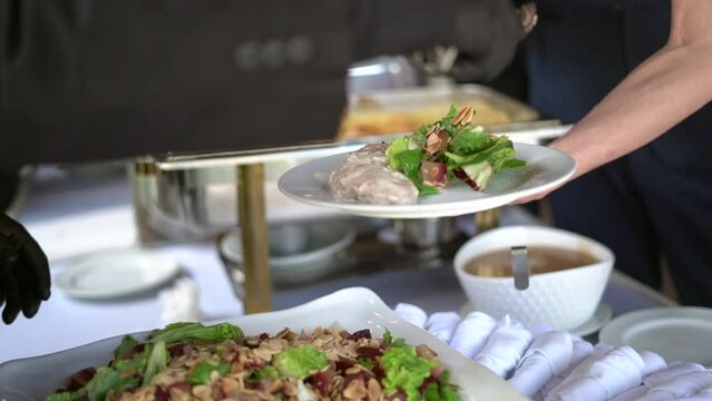 Chef sirviendo ensalada a un comensal en un buffet