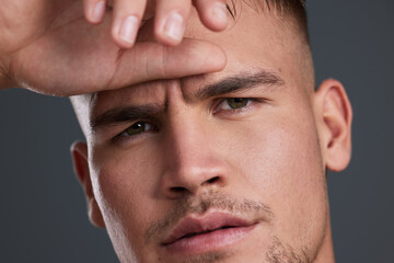 Obraz premium Skincare, confident and portrait of man in studio with natural, cosmetic and grooming face routine. Serious, clean and male person with facial dermatology treatment for health by gray background.