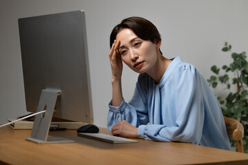パソコン作業に疲れる女性