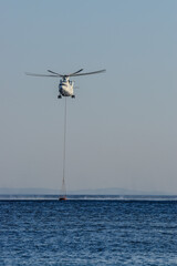 A sea-based firefighting helicopter replenishes water, combating blazes with precision and speed, safeguarding lives and ecosystems © Ömer Aydın