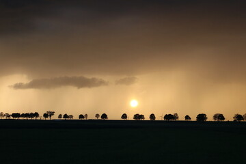 Sunset and rain over the field.