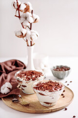 Traditional Italian dessert tiramisu in glasses on white table. Soft focus - 809834714
