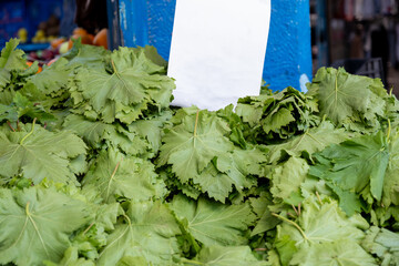 Close up view for grape leafs for sale from above or top view with price tag as copy space on white...