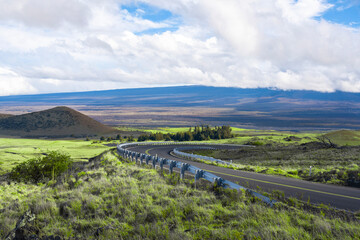 Street road on the top of Mauna Kea volcano mountain view over clouds sky background Big Island Hawaii USA © Jantira