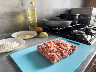  fresh raw minced meat with cake ingredients  oil, flour, egg, onion on the kitchen table
