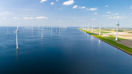 A serene scene of vast water surrounded by elegant windmills in Flevoland, Netherlands. The...