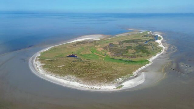 Aerial drone 4K film of the uninhabited island Griend, part of world heritage the Wadden Sea in the Netherlands. Bird sanctuary, protected site, dunes, tidal stream, beach and sand bank in reflection