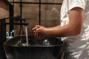 Child, tap and washing hands in water for hygiene, cleaning or bacteria or germ removal in sink at home. Closeup of kid rinsing soap in bathroom basin for disinfection, care or cleanliness at house.