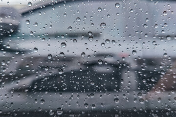 Raindrops on car window on background of cloudy sky