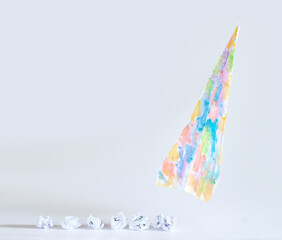 Fresh ideas for business transformation with crumpled paper  and a wild colored paper plane taking...