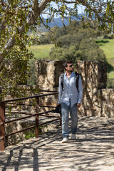 Fototapeta premium man walking through nature with his video camera. Man recording in nature with his video camera. Professional doing a video report in nature. Boy doing nature tourism, traveling with his camera.