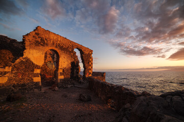 Pumping station ruins at the seashore at the sunset
