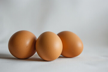 three eggs are sitting on a white surface
