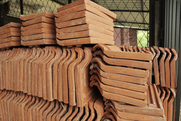 Stack of clay roof tiles in a construction site. Building materials.