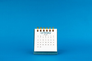 September 2024 mini desk calendar on blue background.