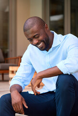 Portrait Of Laughing And Smiling Man Sitting Outdoors On Deck At Home