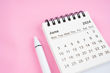 June 2024 month calendar on pink fabric background.