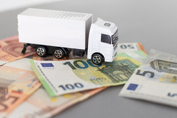 white toy truck on euro banknotes. concept for logistics, transportation and and finance