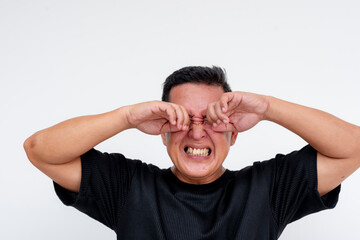 Middle aged Asian man rubbing irritated eyes, isolated on white background
