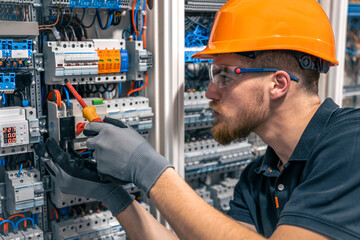 Male electrician working in a switchboard with fuses.