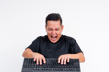 A middle aged man is mad and livid while typing furiously on his keyboard. Toxic online behavior or...